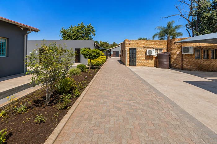 A landscaped paved path leading between Da Silva Academy buildings.
